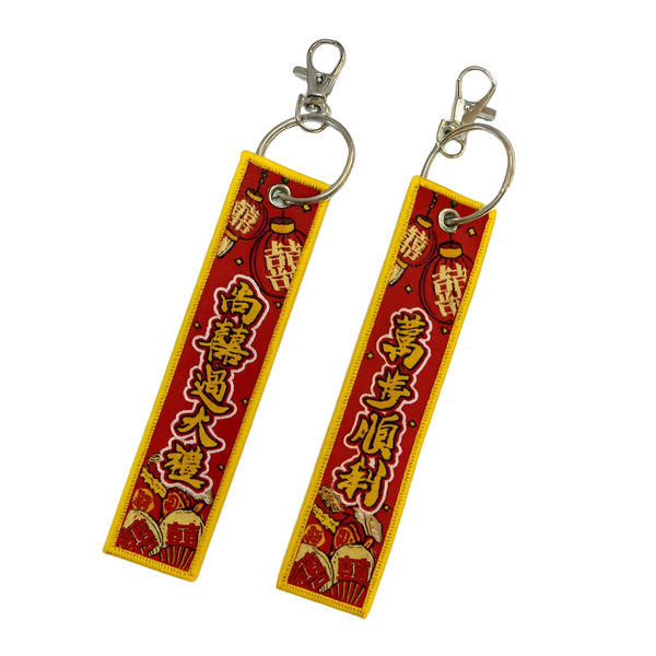Two red and yellow keychains with Chinese characters on a white background