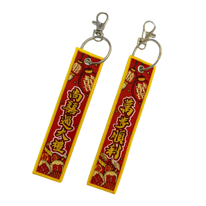 Two red and yellow keychains with Chinese characters on a white background