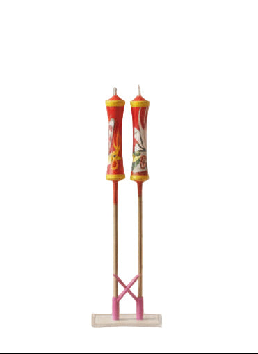 Decorative candles on sticks with colorful designs against a white background